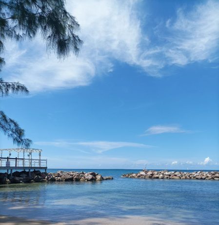 Calm small beach with gentle waves, representing relaxation and feeling at home abroad.